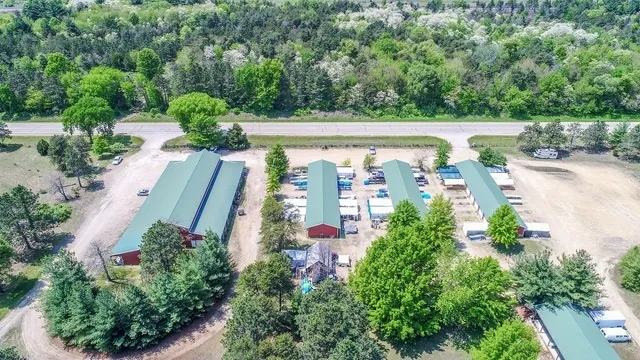 an aerial view of residential house with outdoor space and trees all around