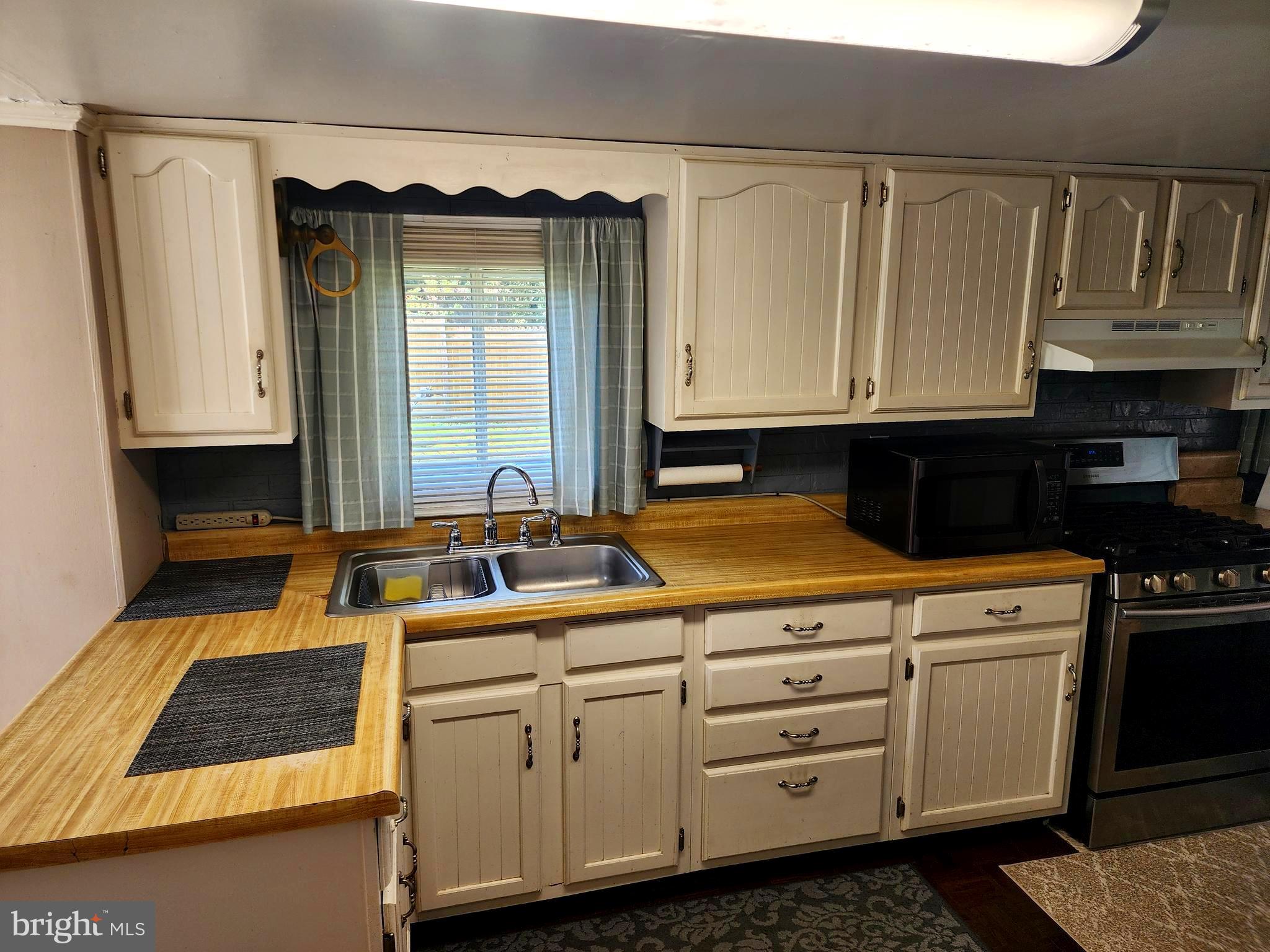 14403 Ellerslie Road Ellerslie, MD 21529 - Photo 23 of 34 a kitchen with white cabinets and sink