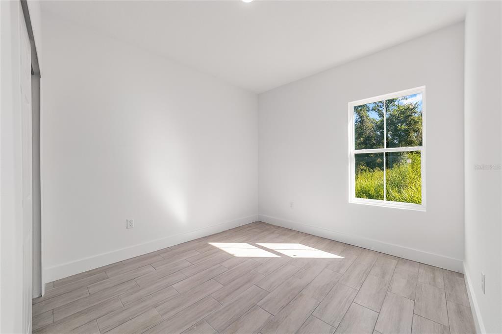 15431 Southwest 41st Street Road Ocala, FL 34481 - Photo 33 of 44 an empty room with wooden floor and windows