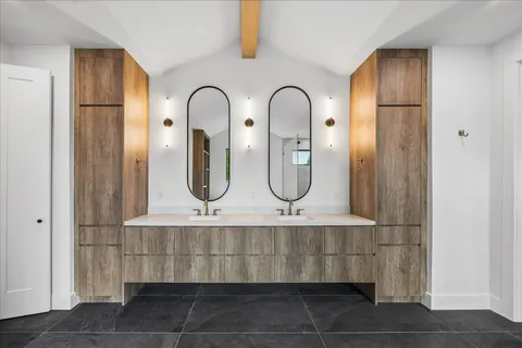 a bathroom with mirror two sinks and a shower