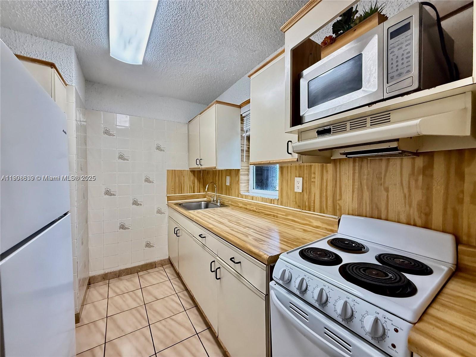 424 Southwest 7th Street, Unit 404 Miami, FL 33130 - Photo 4 of 10 a kitchen with a stove and a microwave
