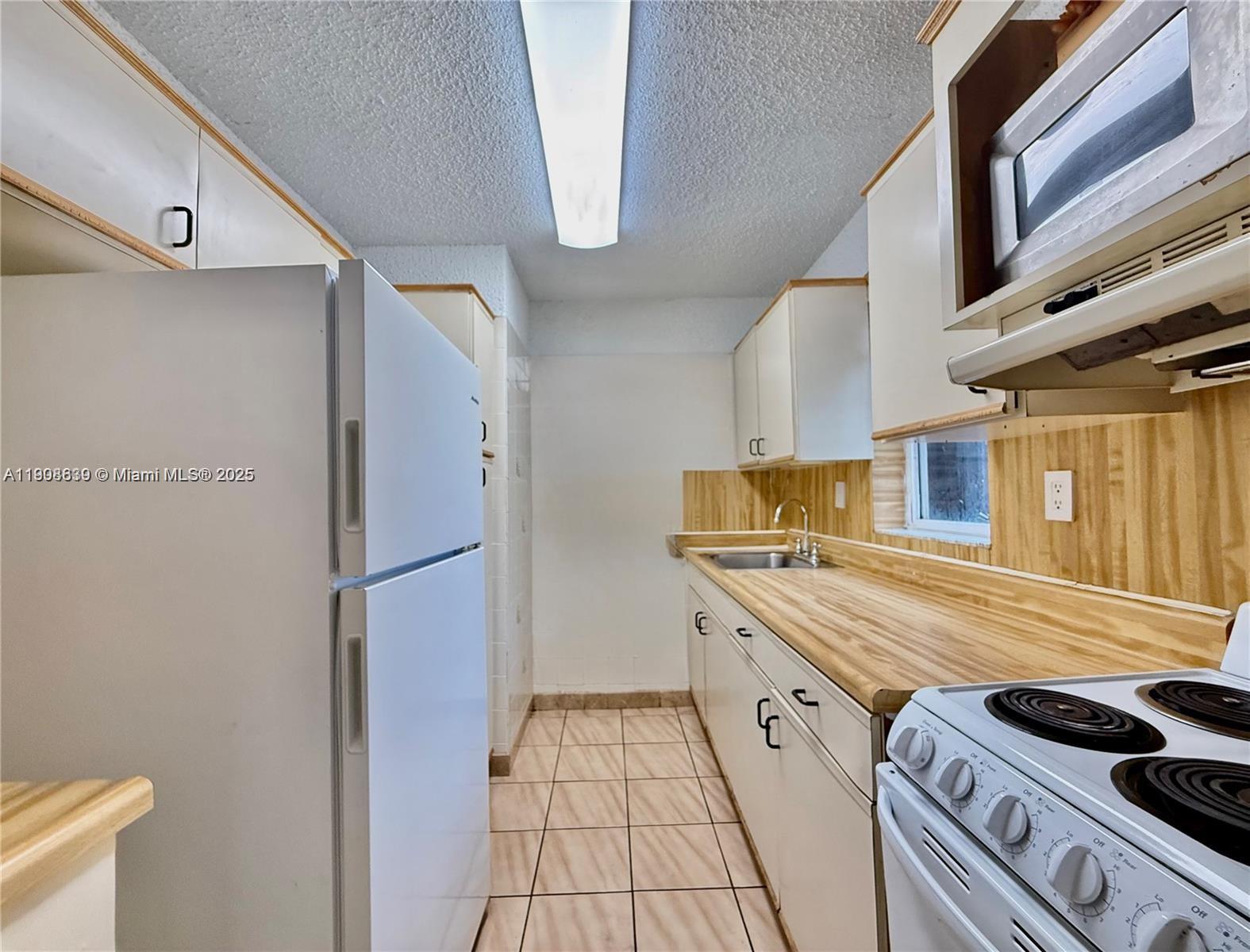 424 Southwest 7th Street, Unit 404 Miami, FL 33130 - Photo 5 of 10 a kitchen with a stove and a refrigerator