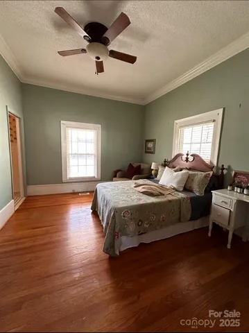 a spacious bedroom with a bed and wooden floor