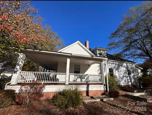 a view of a house with a small yard and wooden fence
