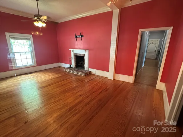 a view of empty room with wooden floor and fireplace