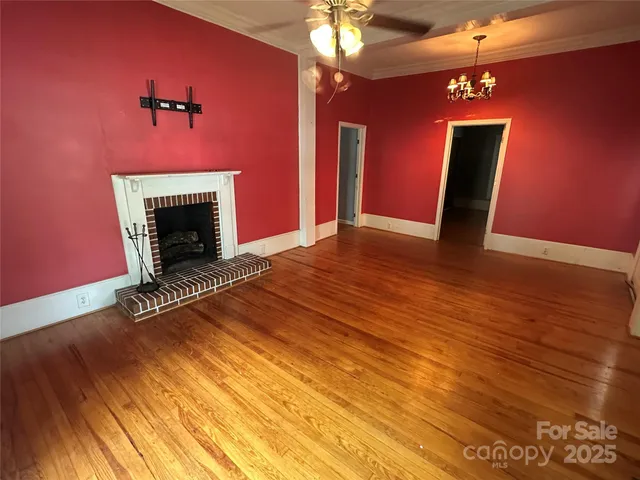 a view of empty room with wooden floor and fireplace