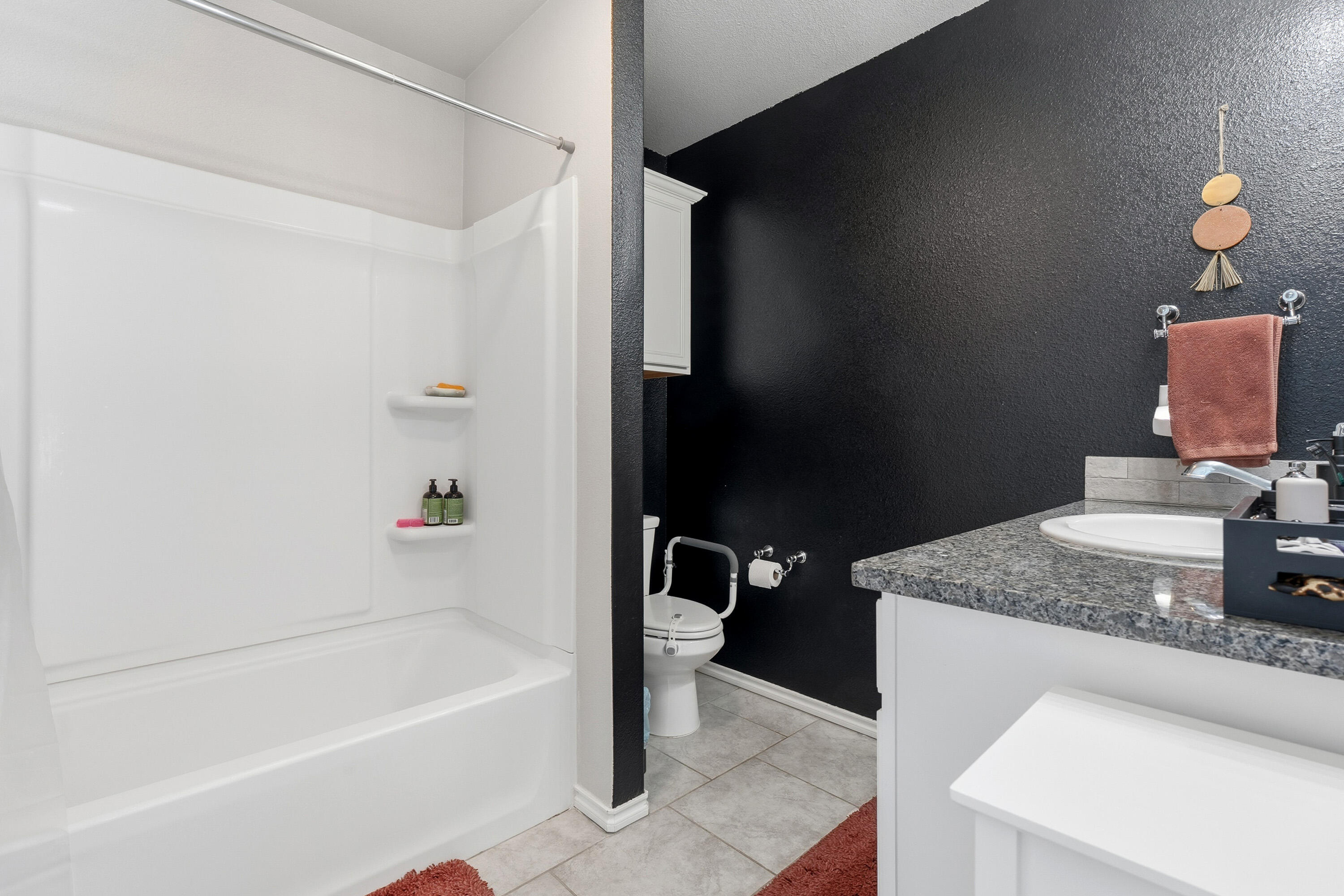 6827 39th Street Lubbock, TX 79407 - Photo 15 of 25 a bathroom with a granite countertop sink a toilet and bathtub
