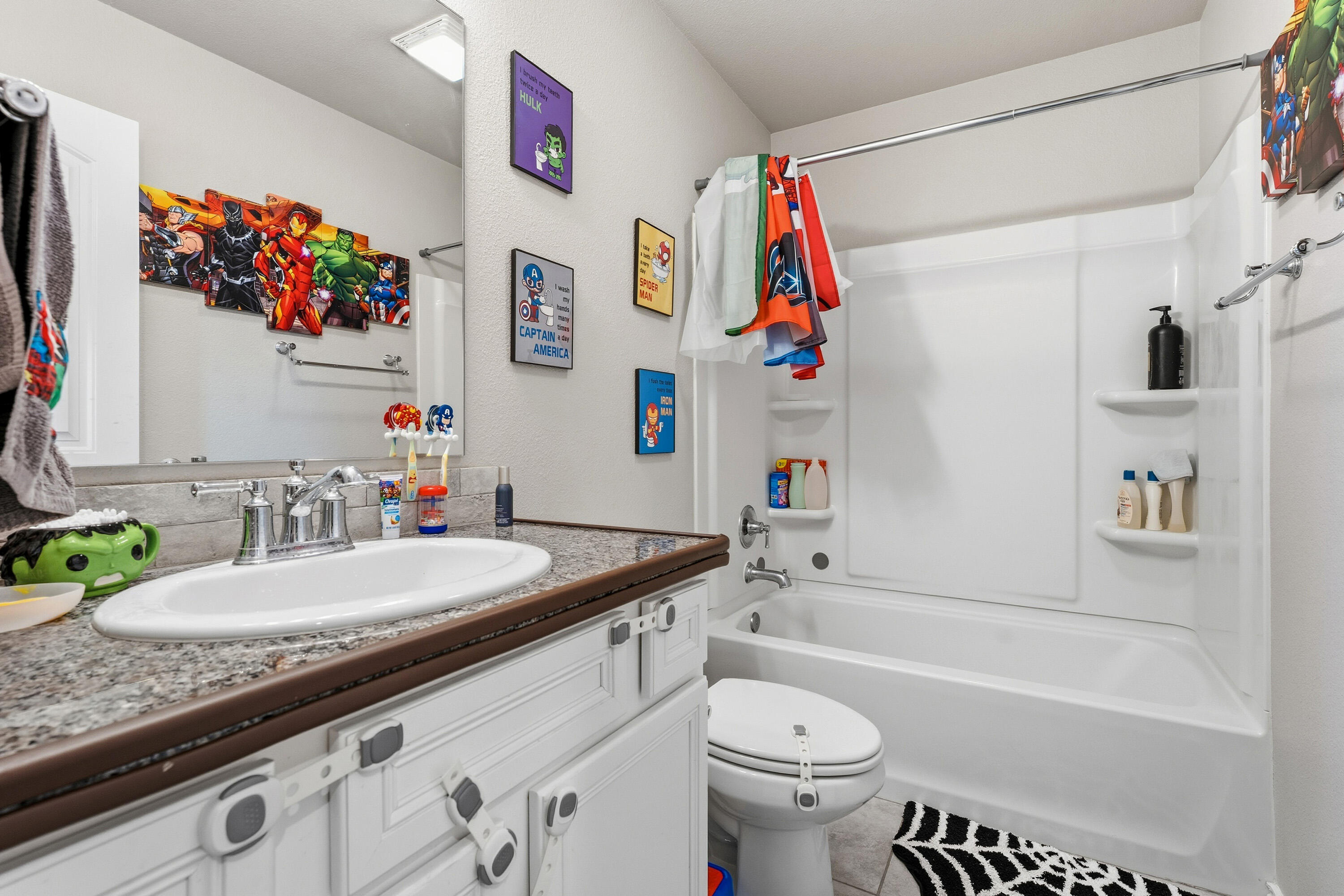 6827 39th Street Lubbock, TX 79407 - Photo 18 of 25 a bathroom with a granite countertop sink a toilet and a bathtub