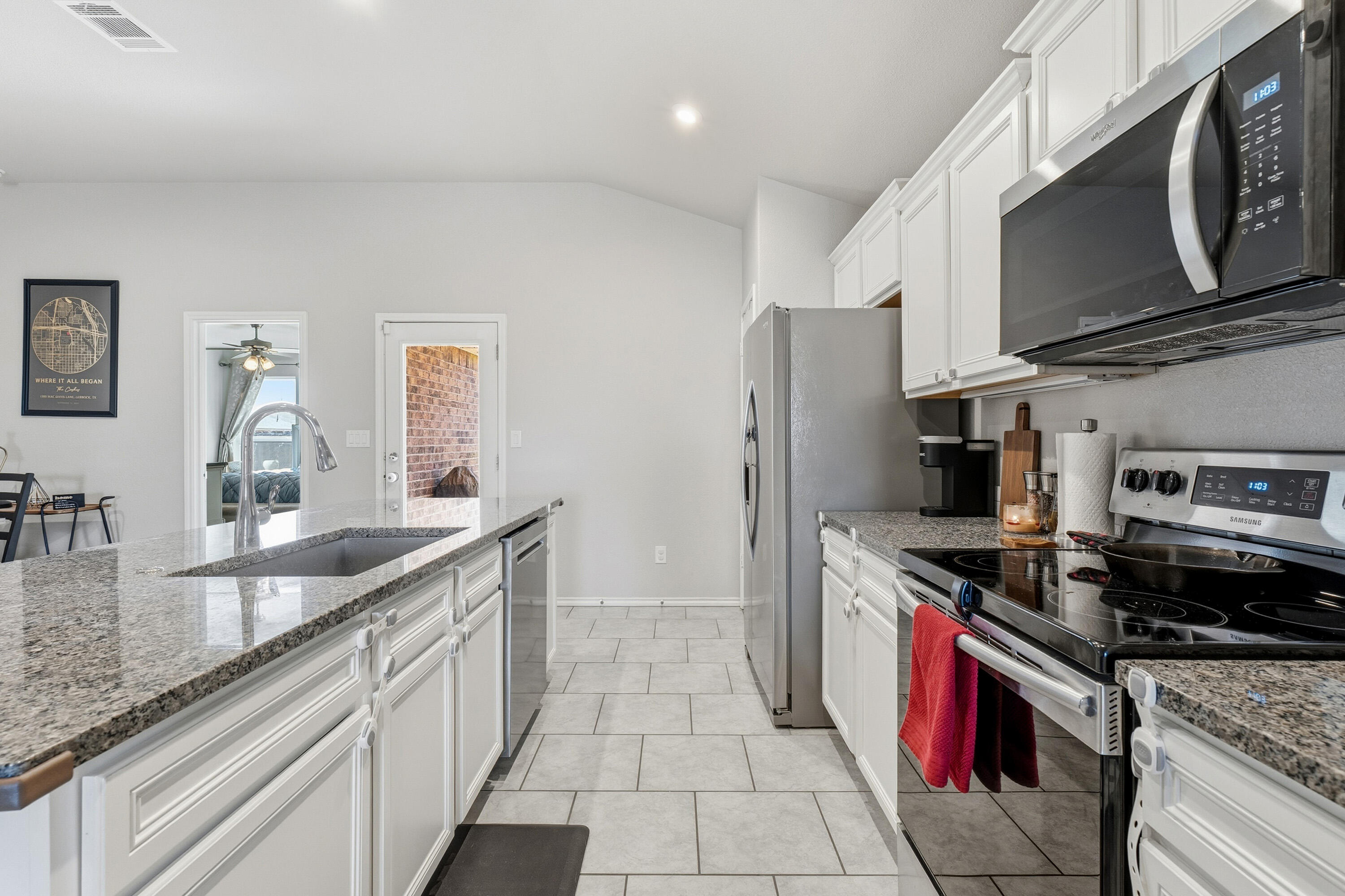 6827 39th Street Lubbock, TX 79407 - Photo 10 of 25 a kitchen with stainless steel appliances granite countertop a sink stove and refrigerator