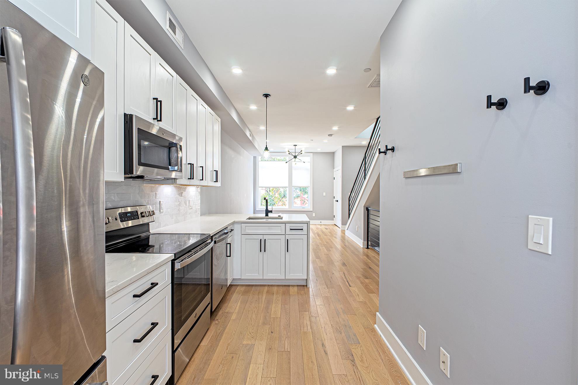 1219 Wylie Street Northeast, Unit 2 Washington, DC 20002 - Photo 13 of 29 a kitchen with white cabinets and stainless steel appliances