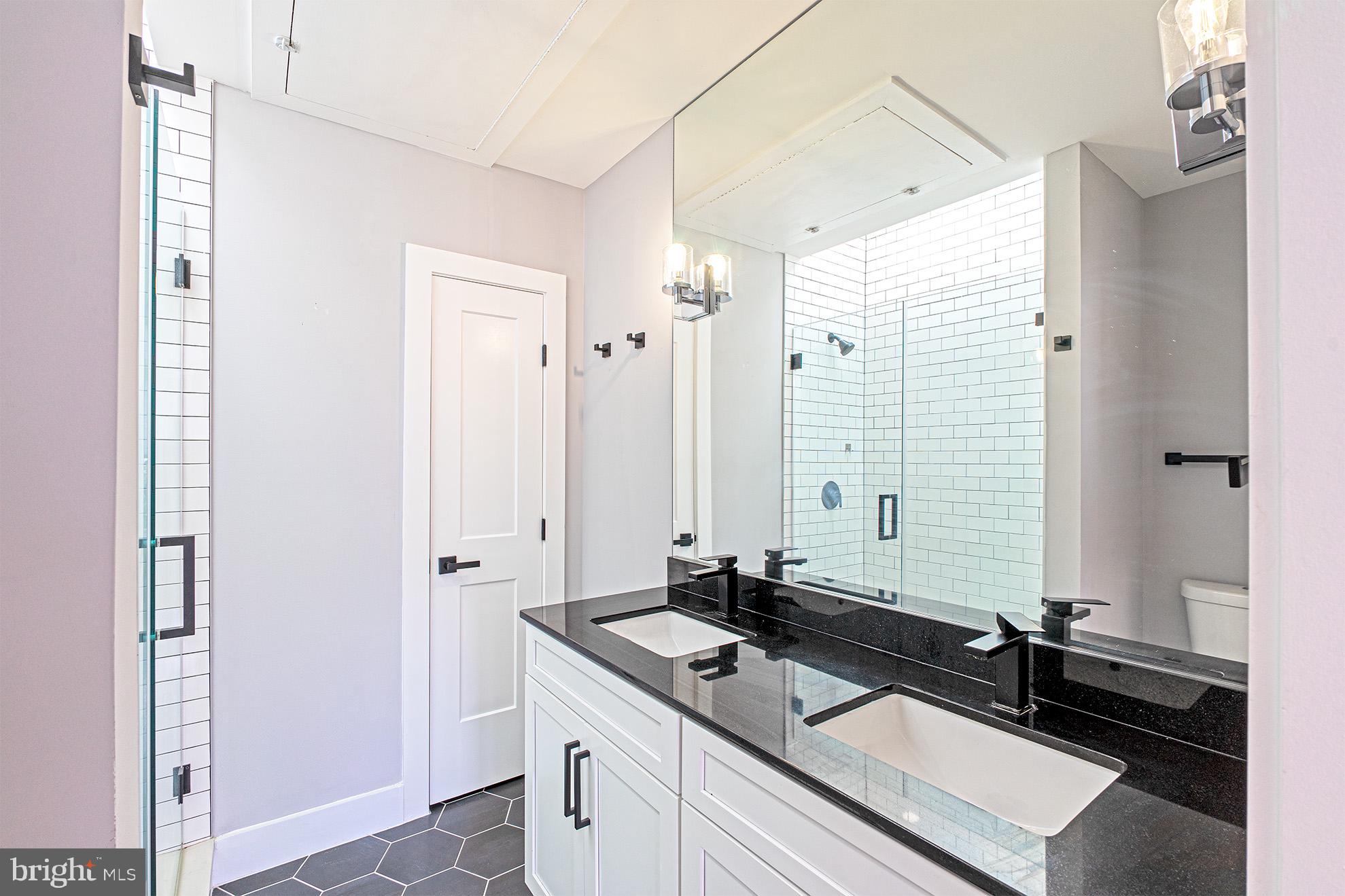 1219 Wylie Street Northeast, Unit 2 Washington, DC 20002 - Photo 19 of 29 a bathroom with a granite countertop sink and a mirror