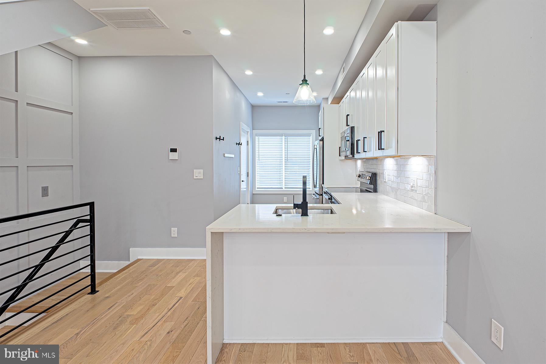 1219 Wylie Street Northeast, Unit 2 Washington, DC 20002 - Photo 9 of 29 a kitchen with kitchen island a sink and a stove top oven