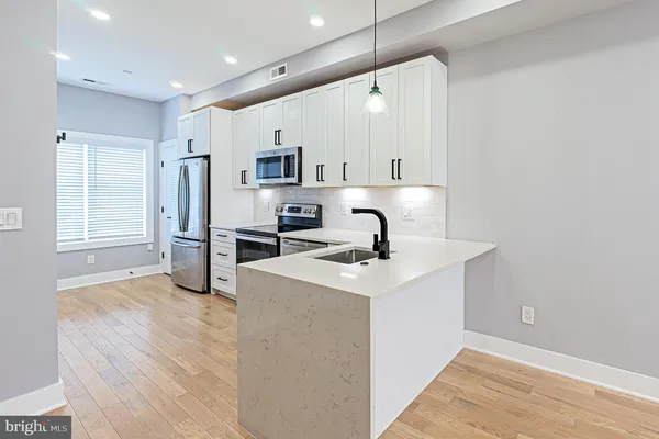 a kitchen with stainless steel appliances a stove a sink and a microwave