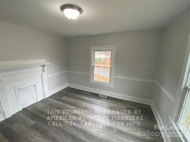 a view of a big room with wooden floor and windows
