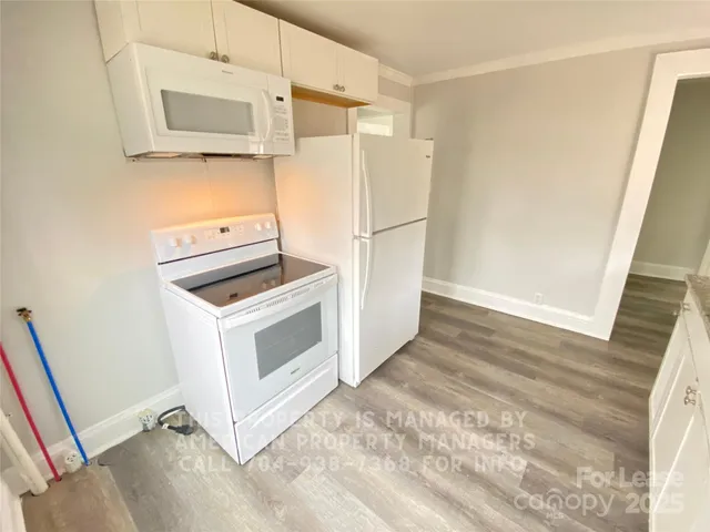 a kitchen with white cabinets and white appliances