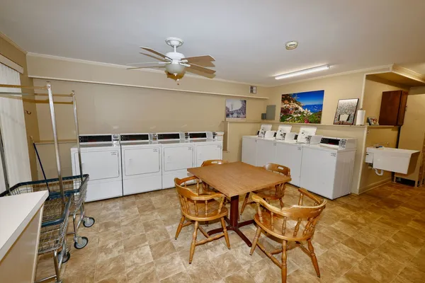 a kitchen with a table chairs refrigerator and microwave
