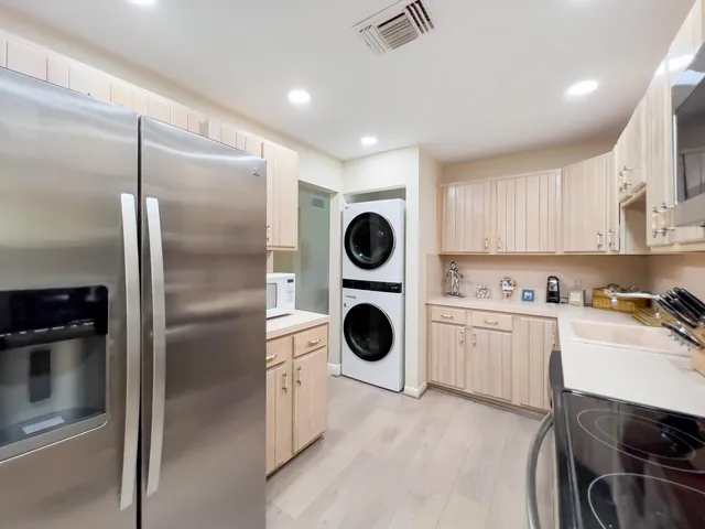 a kitchen with a refrigerator sink and cabinets