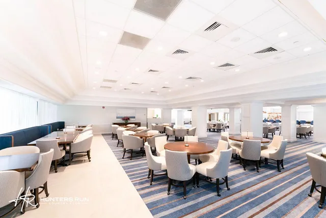 a living room with lots of furniture kitchen view and a flat screen tv