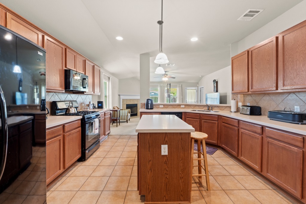 12008 Lansdowne Road Austin, TX 78754 - Photo 11 of 29 A well-appointed kitchen features a central island, tile flooring, and ample cabinetry for culinary pursuits.