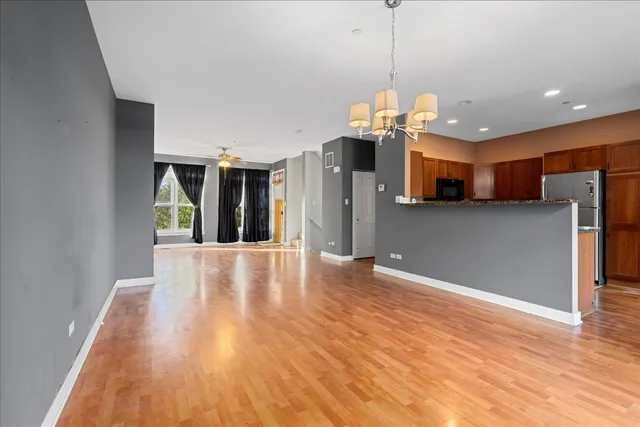 a view of a kitchen with wooden floor and a ceiling fan