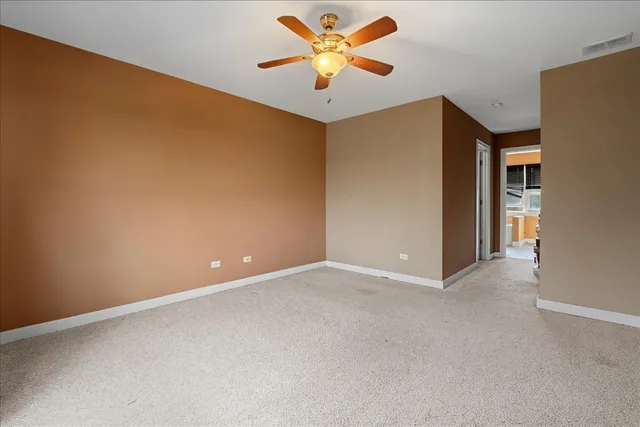 an empty room with closet and a ceiling fan