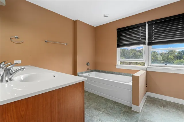 a bathroom with a tub sink and mirror