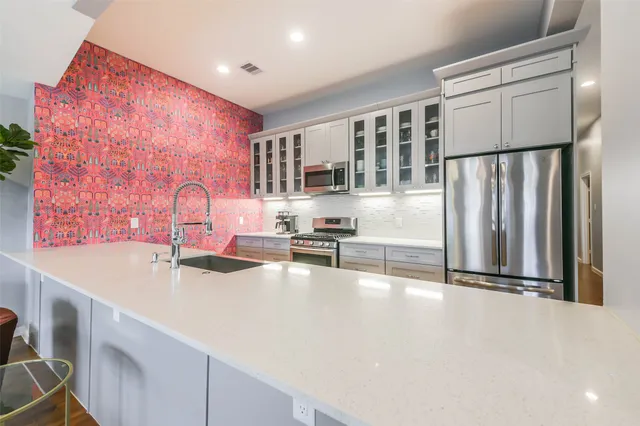 a kitchen with stainless steel appliances a sink and a refrigerator