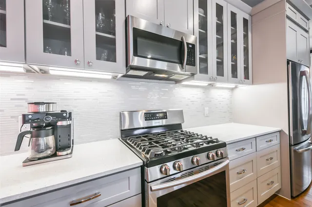 a kitchen with granite countertop a stove and a microwave