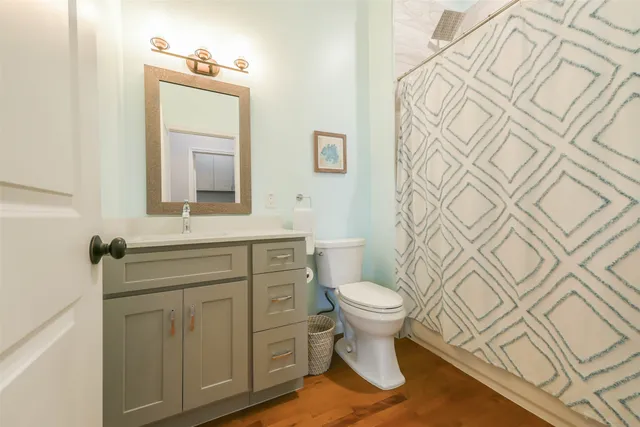 a bathroom with a sink toilet a mirror and shower