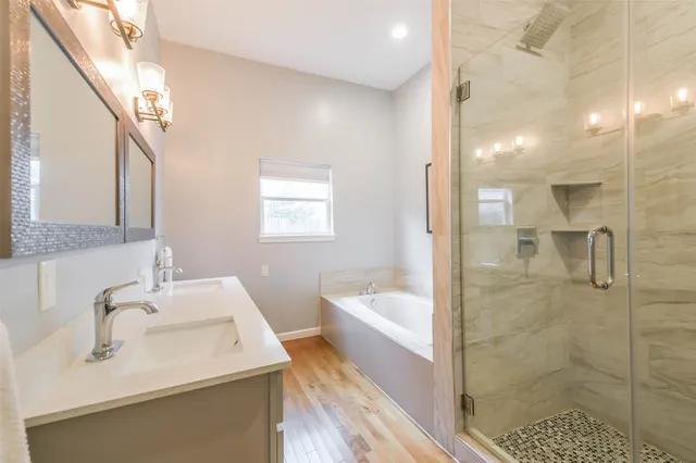 a bathroom with a sink a toilet a mirror and shower