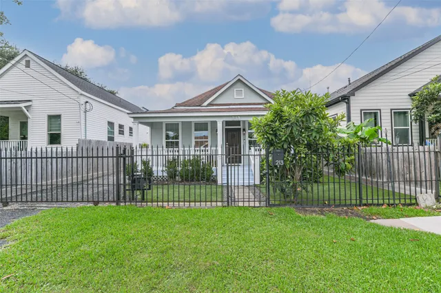 a front view of a house with a garden and yard