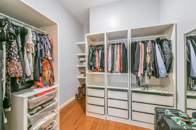 a view of walk in closet with clothes and shoes