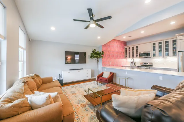 a living room with furniture kitchen view and a window
