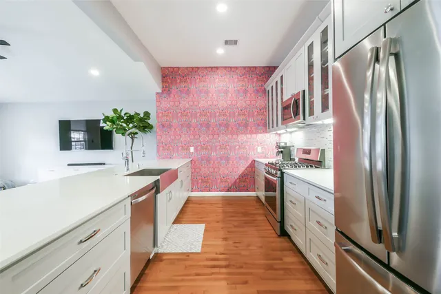 a kitchen with stainless steel appliances a sink and a refrigerator