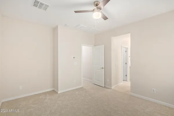 an empty room with a ceiling fan and a fan