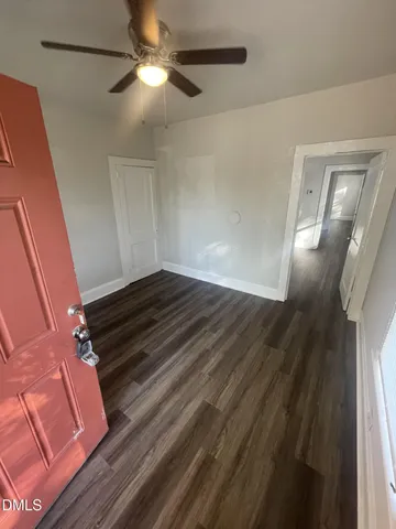 a view of empty room with wooden floor
