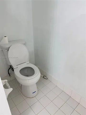 a white toilet sitting next to a white wall