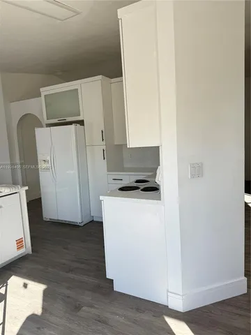 a view of kitchen with wooden floor and electronic appliances