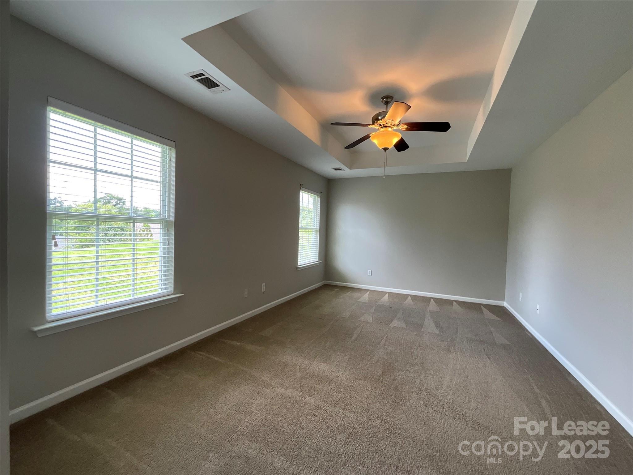 10846 Traders Court Davidson, NC 28036 - Photo 16 of 24 an empty room with windows and chandelier fan
