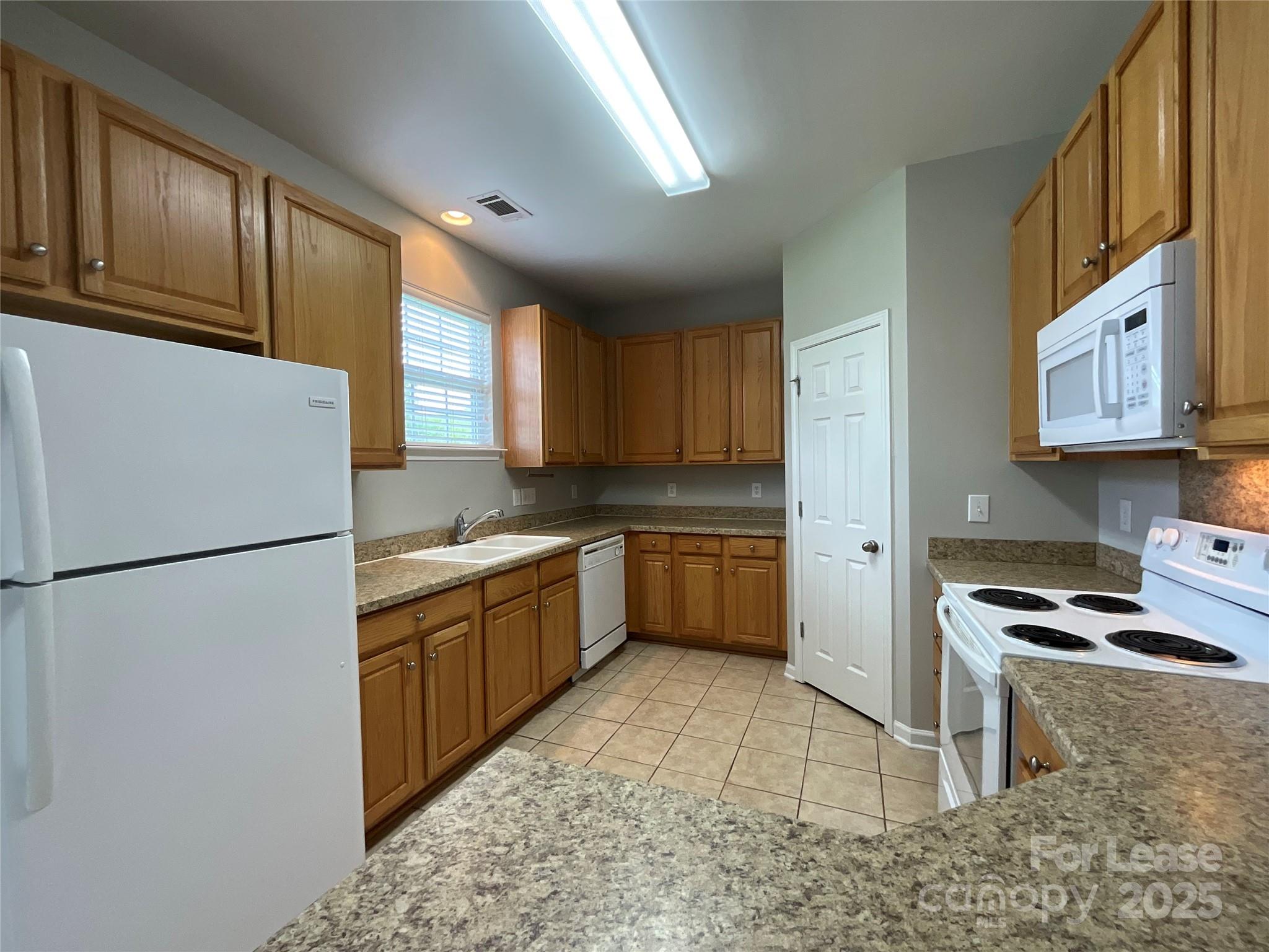 10846 Traders Court Davidson, NC 28036 - Photo 8 of 24 a kitchen with a sink a refrigerator and cabinets