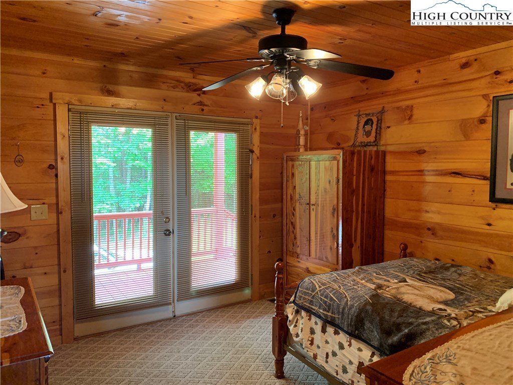 305 Wolf Pen Road Purlear, NC 28665 - Photo 29 of 40 a bedroom with a bed and a chandelier