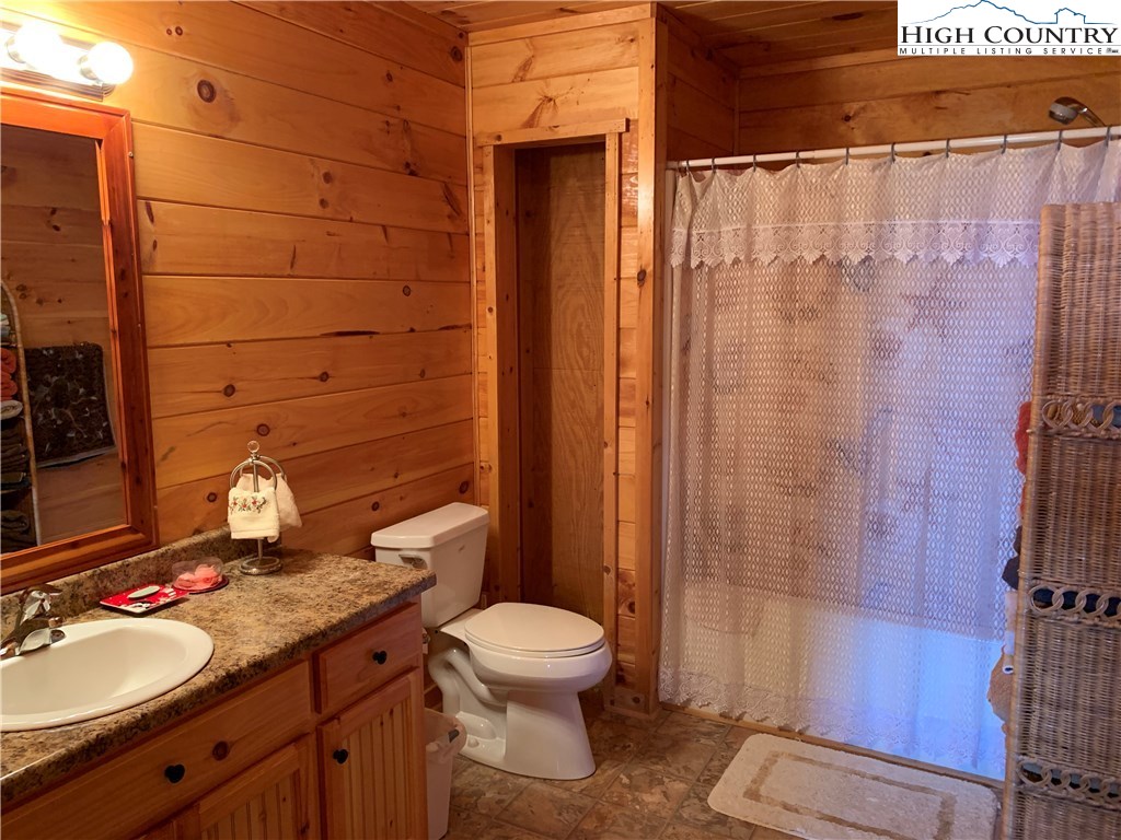 305 Wolf Pen Road Purlear, NC 28665 - Photo 31 of 40 a bathroom with a granite countertop sink toilet and shower