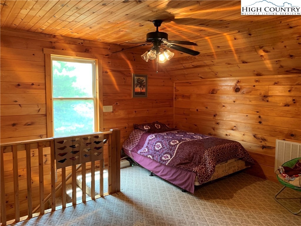 305 Wolf Pen Road Purlear, NC 28665 - Photo 35 of 40 a bedroom with a bed and wooden floor