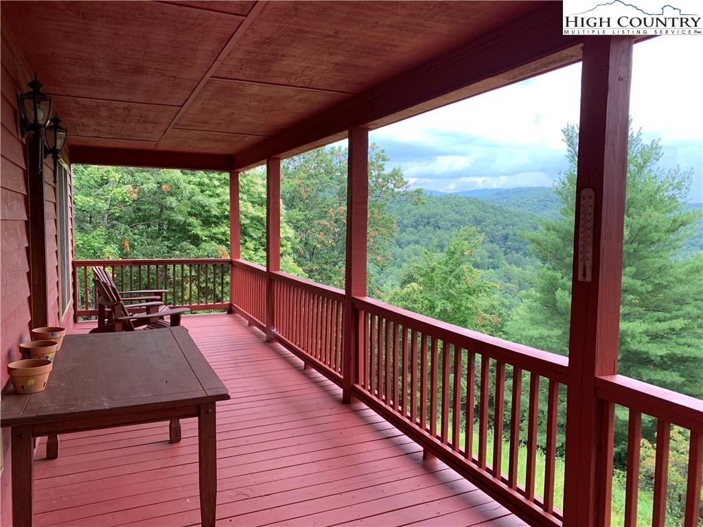 305 Wolf Pen Road Purlear, NC 28665 - Photo 7 of 40 a view of a balcony with wooden floor and outdoor seating