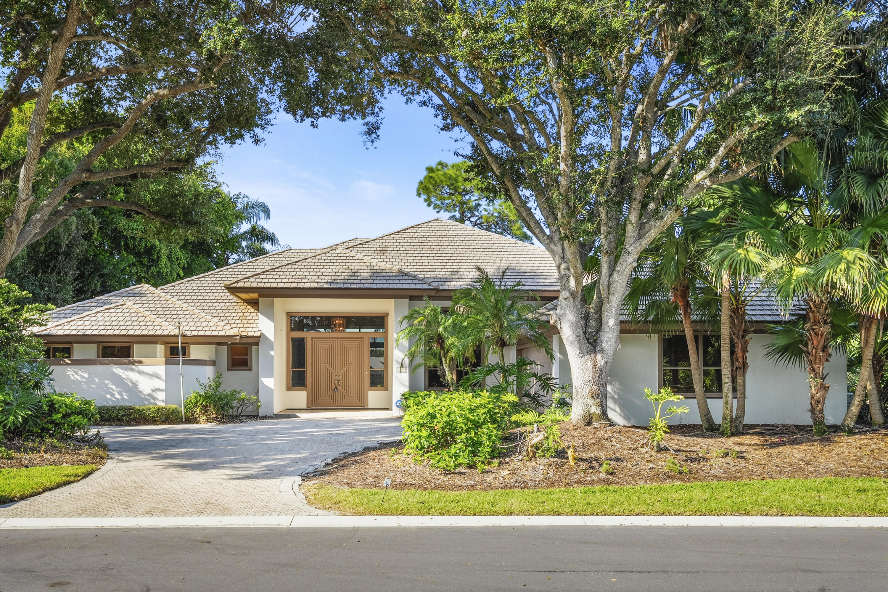 6469 Southeast Baltusrol Terrace Stuart, FL 34997 - Photo 1 of 65 a front view of a house with garden