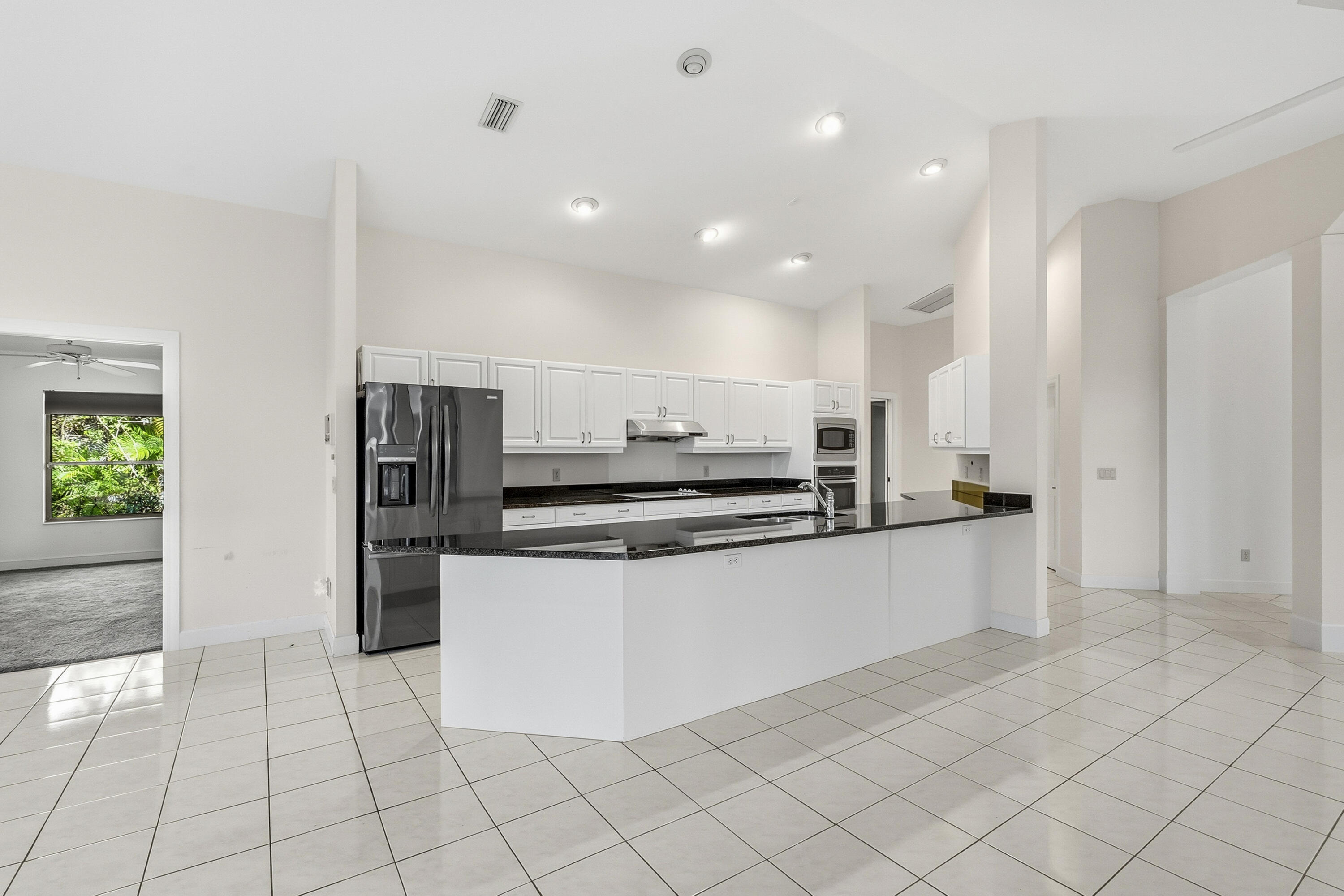 6469 Southeast Baltusrol Terrace Stuart, FL 34997 - Photo 17 of 65 a kitchen with stainless steel appliances a refrigerator and a stove top oven