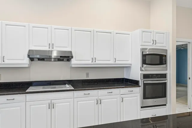 an empty room with ceiling fan and windows