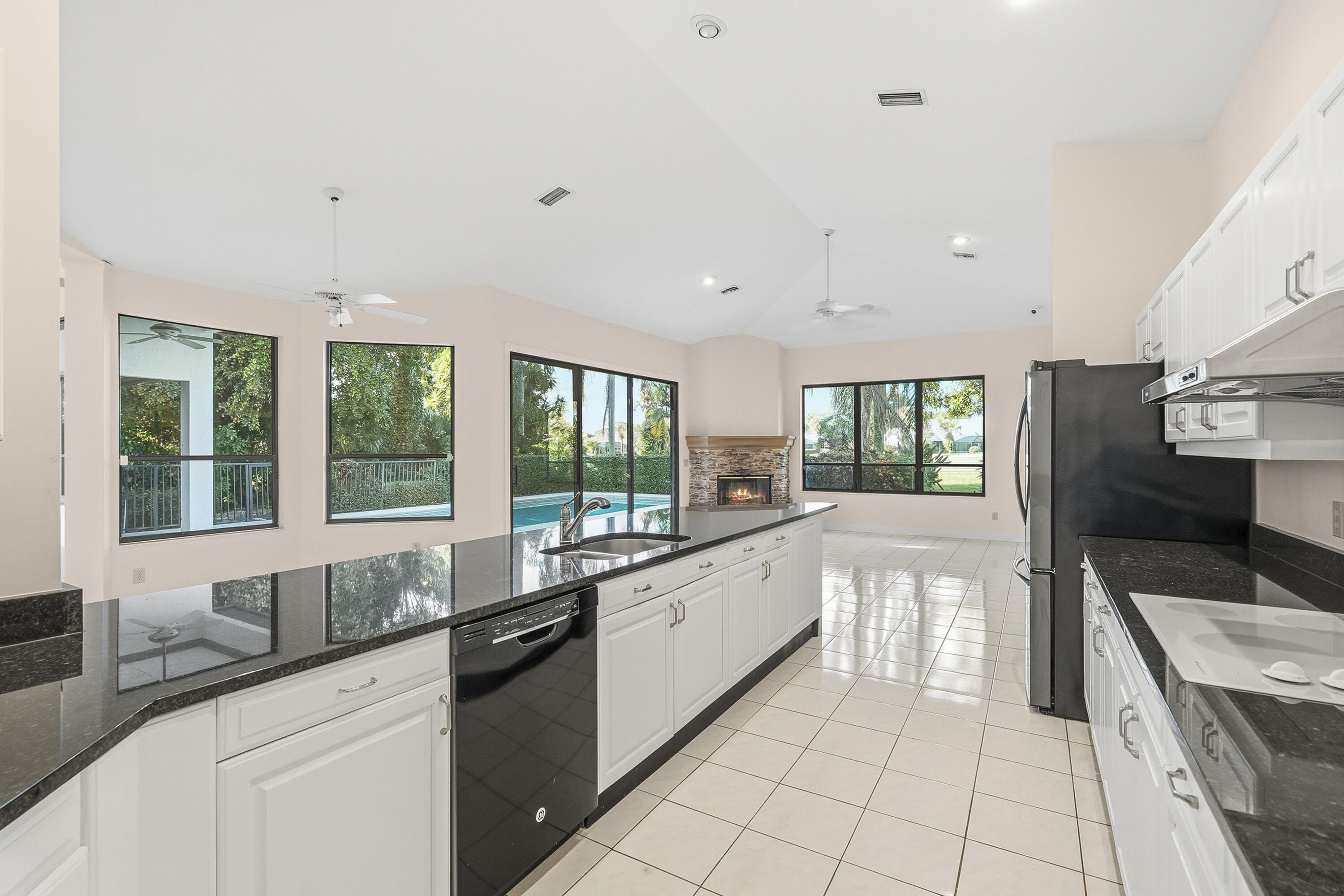 6469 Southeast Baltusrol Terrace Stuart, FL 34997 - Photo 19 of 65 a large white kitchen with granite countertop a large window and a sink