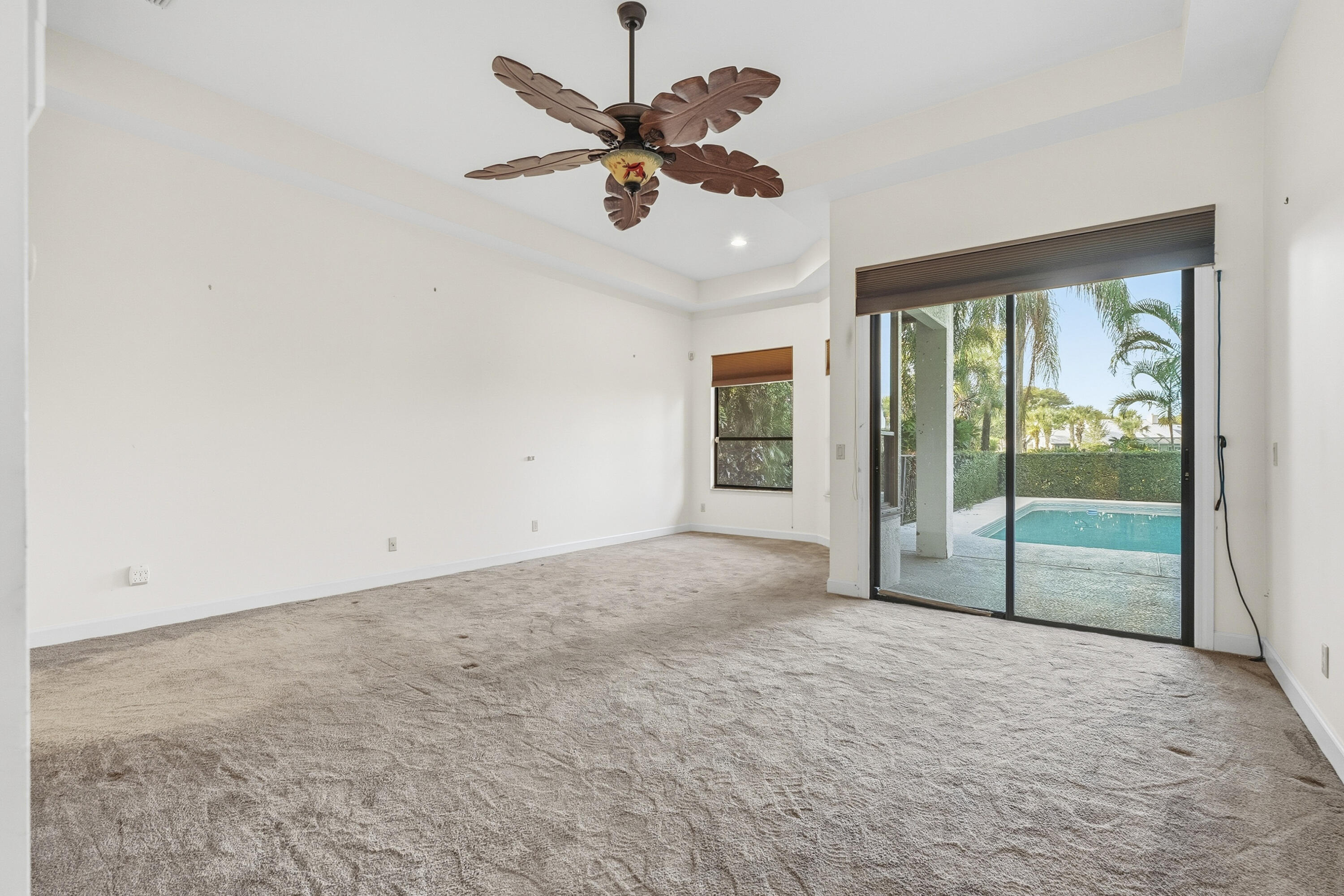 6469 Southeast Baltusrol Terrace Stuart, FL 34997 - Photo 23 of 65 an empty room with ceiling fan and windows