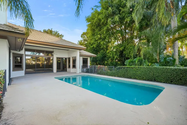 a view of house with swimming pool and a yard